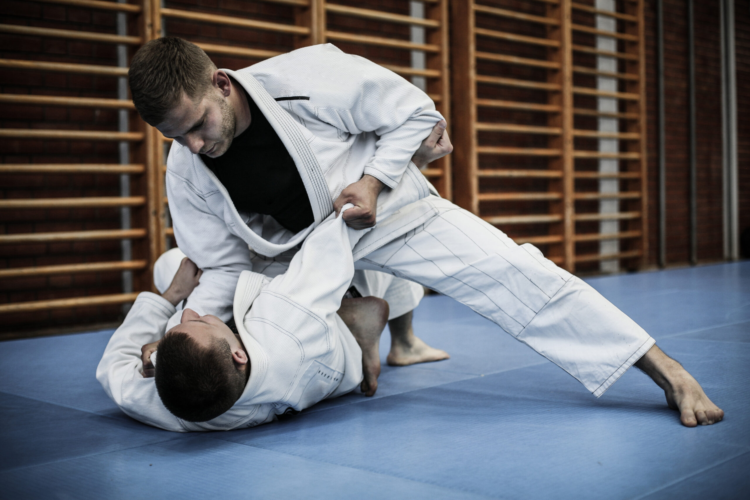 Two adult male judo practitioners sparring in white gis at Darfight Judo dojo in Brooklyn